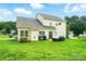 Back exterior of home with a patio area and green lawn at 12803 Matisse Ln, Charlotte, NC 28215