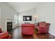 Cozy living room featuring a fireplace, hardwood floors, and bright natural light at 12803 Matisse Ln, Charlotte, NC 28215