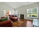 Open-concept living room with a cozy fireplace, hardwood floors and plenty of natural light at 12803 Matisse Ln, Charlotte, NC 28215