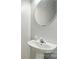 A half-bathroom with pedestal sink and oval mirror at 12803 Matisse Ln, Charlotte, NC 28215
