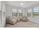 A sunny bedroom featuring large windows with natural light and comfortable chairs with neutral walls and carpet at 1287 Fishing Creek Rd, Lake Wylie, SC 29710