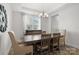A dining room with a rustic wood table, elegant chandelier, and natural light at 1287 Fishing Creek Rd, Lake Wylie, SC 29710