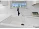 A farmhouse-style kitchen sink with a black faucet and a view from the window provides a bright and functional space at 1287 Fishing Creek Rd, Lake Wylie, SC 29710