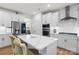 Modern kitchen with white cabinetry, stainless steel appliances, and a large quartz island with chairs at 1287 Fishing Creek Rd, Lake Wylie, SC 29710