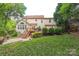Well-manicured backyard featuring a back deck, trees, and lush lawn at 13312 Edgetree Dr, Pineville, NC 28134