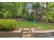 Grassy backyard featuring trees, a fence, and a small playset at 13312 Edgetree Dr, Pineville, NC 28134