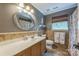 Elegant bathroom with a stylish vanity, decorative mirror, and a patterned shower curtain at 13312 Edgetree Dr, Pineville, NC 28134