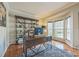 Home office with custom shelving, hardwood floors, a plush rug, and natural light at 13312 Edgetree Dr, Pineville, NC 28134