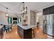 Open concept kitchen featuring a center island with barstool seating, stainless steel appliances, and a modern light fixture at 13312 Edgetree Dr, Pineville, NC 28134