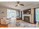 Bright living room with fireplace, mounted tv, and open to the sunroom at 13312 Edgetree Dr, Pineville, NC 28134