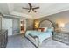 Comfortable main bedroom with trey ceiling, gray walls, two bedside tables, and view to the ensuite bath at 13312 Edgetree Dr, Pineville, NC 28134