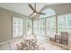Sunroom offers natural light with large windows, decorative ceiling fan, and playful rug at 13312 Edgetree Dr, Pineville, NC 28134