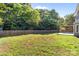 A view of the backyard with a well-maintained lawn, mature trees, and privacy fence at 13914 Loch Loyal Dr, Charlotte, NC 28273