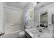 A bright bathroom with a shower-tub, and a vanity with a white top and neutral colored cabinet at 13914 Loch Loyal Dr, Charlotte, NC 28273