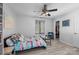 A cozy room with a bed, side table, chair, ceiling fan and closet with blue door at 13914 Loch Loyal Dr, Charlotte, NC 28273