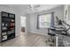 A room with a desk, ceiling fan, a view into the connected bathroom, and light gray flooring at 13914 Loch Loyal Dr, Charlotte, NC 28273