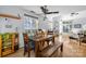 Light-filled dining room boasts a rustic wooden table, bench, and chairs, complemented by large windows and wood flooring at 13914 Loch Loyal Dr, Charlotte, NC 28273