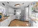 Well-lit kitchen with stainless steel refrigerator, white cabinetry, and wood-look flooring at 13914 Loch Loyal Dr, Charlotte, NC 28273