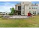 Exterior of home features a backyard with a stone patio, outdoor kitchen, and lush green lawn at 14218 Morningate St, Huntersville, NC 28078