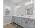 Bright bathroom featuring a double vanity with modern fixtures, herringbone floors, and a glass-enclosed shower at 14218 Morningate St, Huntersville, NC 28078