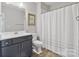 Neutral bathroom features gray vanity with white countertop and shower with blue striped curtain at 14218 Morningate St, Huntersville, NC 28078