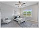 Serene bedroom with a white bed frame, plush chair, and abundant natural light from a window at 14218 Morningate St, Huntersville, NC 28078