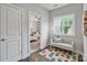 Bright hallway featuring hardwood floors, a colorful rug, and a comfortable bench near a window at 14218 Morningate St, Huntersville, NC 28078