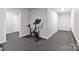 A clean home gym featuring stationary bike and open floor plan with gray flooring at 14218 Morningate St, Huntersville, NC 28078