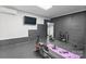 Dedicated home gym space with gray wall, air conditioning, a television, and workout equipment at 14218 Morningate St, Huntersville, NC 28078