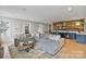 Inviting living room with a large sectional sofa, custom bar and hardwood flooring, ideal for entertaining at 14218 Morningate St, Huntersville, NC 28078