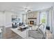 Bright living room features a stone fireplace, large clock, modern furniture, and a ceiling fan at 14218 Morningate St, Huntersville, NC 28078