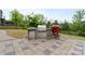 Outdoor kitchen features stone surround, stainless steel appliances, and a Kamado grill at 14218 Morningate St, Huntersville, NC 28078