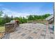 Elegant outdoor patio with built-in stone kitchen, fire pit, and beautifully landscaped backyard at 14218 Morningate St, Huntersville, NC 28078