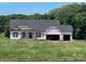 New construction home showcasing a two-car garage and lush, green surroundings at 1479 Mocksville Hwy # 23, Statesville, NC 28625