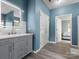 Stylish bathroom featuring a gray vanity with marble countertop, illuminated mirror, and blue painted walls at 1579 Matthews Dr, Rock Hill, SC 29732