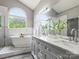 Bright bathroom featuring a double vanity, soaking tub, and a large arched window at 1579 Matthews Dr, Rock Hill, SC 29732