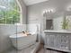 Bathroom with a soaking tub beneath an arched window and a double vanity at 1579 Matthews Dr, Rock Hill, SC 29732