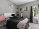 Cozy bedroom with dark patterned bedding, carpet flooring, and natural light from the window at 1579 Matthews Dr, Rock Hill, SC 29732