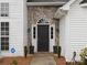 Up close view of front door with sidelights, decorative stone, and manicured landscaping at 1579 Matthews Dr, Rock Hill, SC 29732
