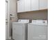 Clean laundry room with washer, dryer, and overhead cabinets at 1579 Matthews Dr, Rock Hill, SC 29732