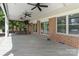 Spacious covered back deck featuring a bar area with stools, ceiling fans, and views of the surrounding greenery at 17112 Green Dolphin Ln, Cornelius, NC 28031