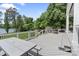 Large back deck with a picnic table and cozy stone fire pit offering picturesque views of the tranquil lake at 17112 Green Dolphin Ln, Cornelius, NC 28031