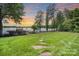 Scenic backyard view leading to a lake, showcasing a well-maintained lawn, a dock, and mature trees at 17112 Green Dolphin Ln, Cornelius, NC 28031