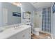 Fresh bathroom featuring a white vanity, shelving unit, tub with shower, and light-blue walls at 17112 Green Dolphin Ln, Cornelius, NC 28031