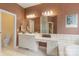 Well-lit bathroom with a large mirror, vanity, bathtub, and toilet at 17112 Green Dolphin Ln, Cornelius, NC 28031