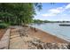 Beautiful lakefront beach with chairs near the water at 17112 Green Dolphin Ln, Cornelius, NC 28031