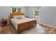 Bright bedroom featuring a wooden bed frame, neutral rug, and two windows offering lots of natural light at 17112 Green Dolphin Ln, Cornelius, NC 28031