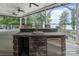 The covered back porch features a lake view, a stone bar with sink and refrigerator and three stools at 17112 Green Dolphin Ln, Cornelius, NC 28031