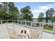 Outdoor deck featuring serene lake views, slate flooring, white railings, and rocking chairs at 17112 Green Dolphin Ln, Cornelius, NC 28031