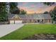 Charming brick home features a manicured lawn, mature trees, and an attached two-car garage at 17112 Green Dolphin Ln, Cornelius, NC 28031